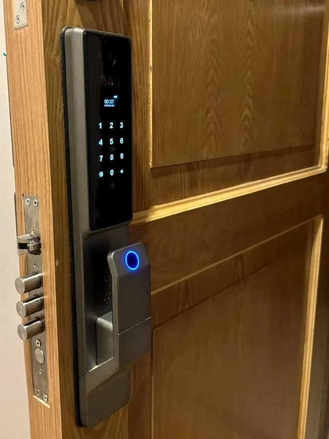 Cerradura con reconocimiento facial instalada en puerta de madera clara