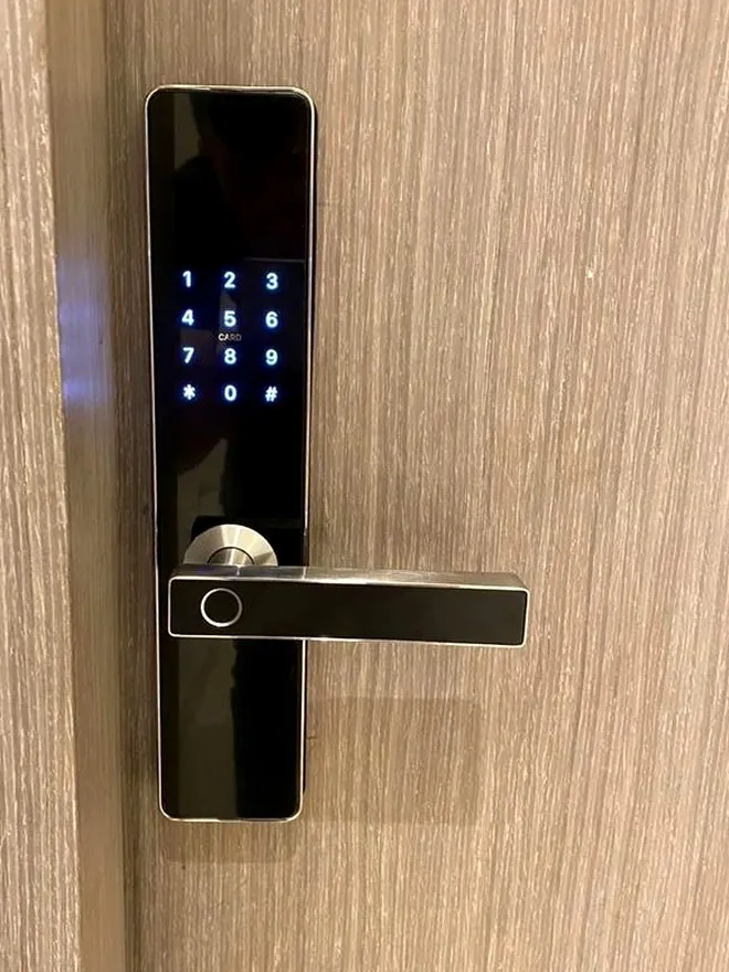 Cerradura electrónica con teclado iluminado instalada en puerta de madera